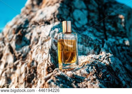A Glass Transparent Rectangular Bottle Of Golden Perfume Standing On A Gray Marble Stone. Parfumery 