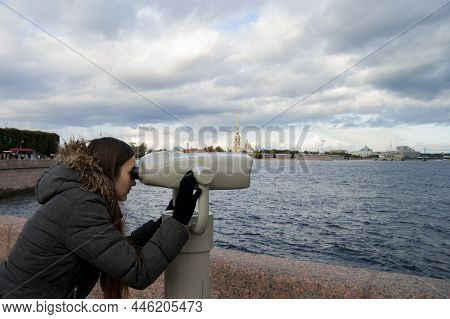 Girl Looks In Binoscope On City. Walk Around St. Petersburg