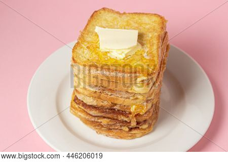 Eggy Bread On A Pink Background. Butter Melts On A Stack Of Eggy Breads. Tasty Breakfast.