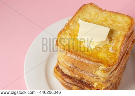 Eggy Bread On A Pink Background. Butter Melts On A Stack Of Eggy Breads. Tasty Breakfast.