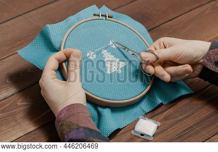 Craftsperson Cutting Thread With Scissors In Indoors.