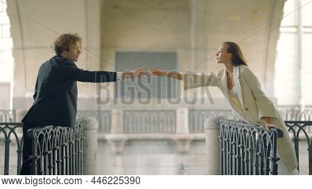 Lovers Hold Out Their Hands To Each Other At Distance. Action. Beautiful Couple In Love On Different