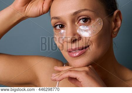 Close-up Portrait Of A Beautiful Smiling Woman Applying Gold Medical Hydrogel Collagen Eye Patches T
