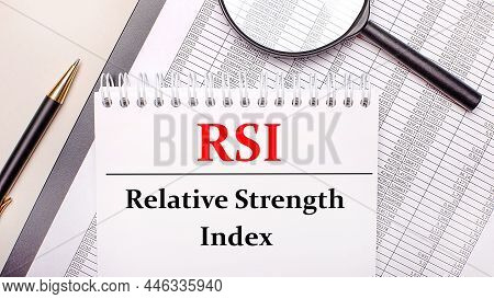 Desktop Magnifier, Reports, Pen And Notebook With Text Rsi Relative Strength Index. Business Concept