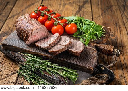 Roast Veal Tenderloin, Sliced Roastbeef On Wooden Board With Garnish. Wooden Background. Top View
