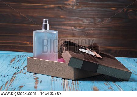 Shooting In The Studio. Artificial Light. Perfume Bottle On A Wooden Background In Retro Style. Next