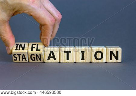 Inflation And Stagnation Symbol. Businessman Turns Cubes, Changes The Word Inflation To Stagnation. 