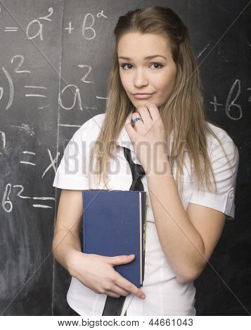 Ritratto di uno studente piuttosto carino con libro vicino a lavagna