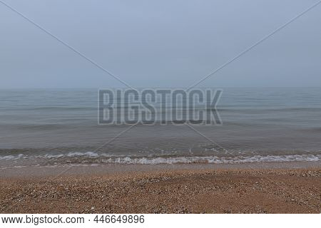 Calm On A Foggy Shell Beach In Morning