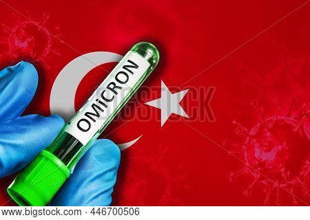 Turkey Outbreak Of Omicron Variant. Hand Holds A Test Tube With Covid-19 Virus Omicron In Front Of T