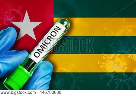 Togo Outbreak Of Omicron Variant. Hand Holds A Test Tube With Covid-19 Virus Omicron In Front Of Tog