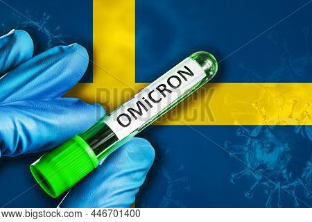Sweden Outbreak Of Omicron Variant. Hand Holds A Test Tube With Covid-19 Virus Omicron In Front Of S