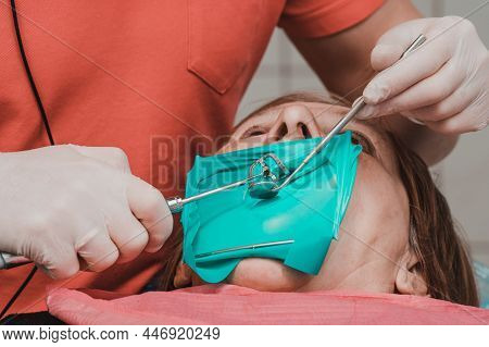 A Patient With A Cheek Retractor With A Green Cofferdam In A Dental Clinic, A Dentist In Latex Glove