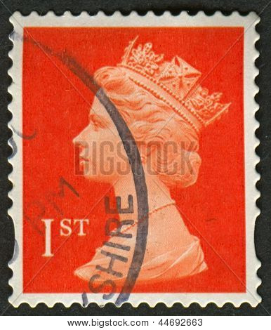 UK-CIRCA 1990:A stamp printed in UK shows image of Elizabeth II is the constitutional monarch of 16 sovereign states known as the Commonwealth realms, in red, circa 1990.