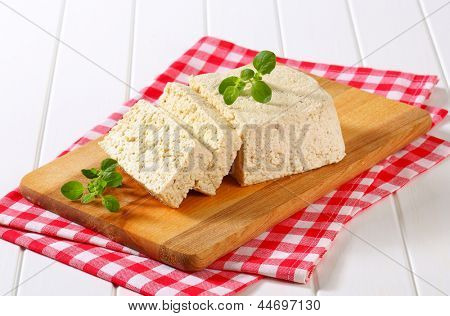 blocco di fetta di tofu naturale su un tagliere di legno