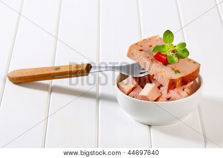 část leberkase v misce vidličkou