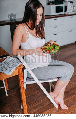 Pregnant Eating Healthy Food. Pregnant Woman In The Kitchen. Pregnant Eats Green Salad. Pregnant On