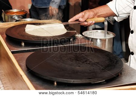 Creperie buffet with a chef preparing a crepe (pancake) 