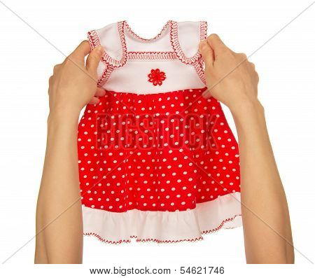 Female hands holding a baby dress