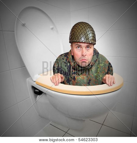 Cowardly soldier hiding in the toilet bowl. Funny picture from army.
