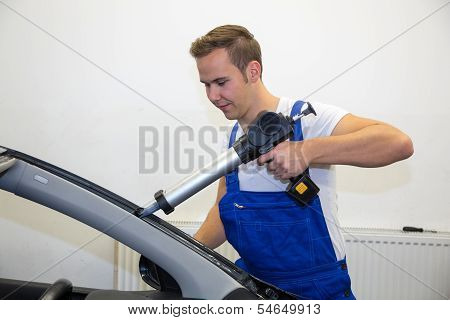 Glazier With Application Gun In Garage Replacing Windshield Or Windscreen