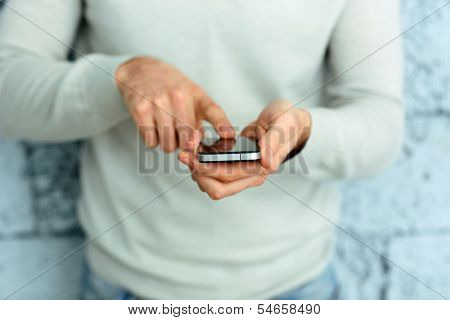 Closeup image of a male hand holding smartphone 