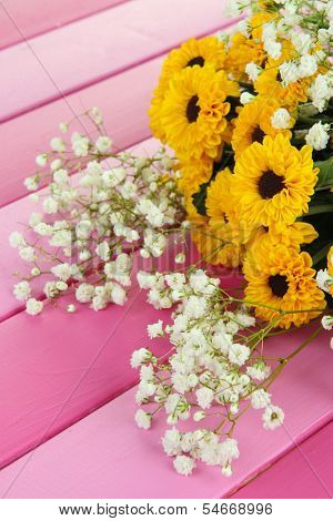 Beautiful flowers on wooden background