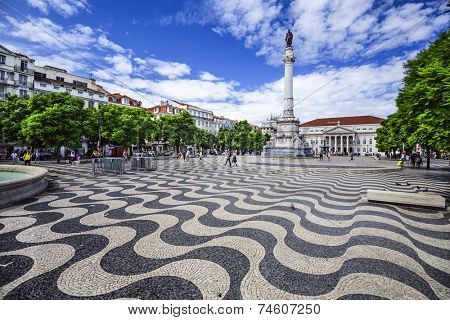 LISBON, PORTUGAL - OCTOBER 13, 2014: Pedestrians stroll through Rossio Square. Officially called Pedro IV Square, it serve as a popular meeting point for tourists and locals alike.