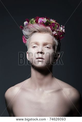 Beauty. Young Man With Wreath Of Flowers Over Gray