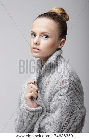 Portrait Of Young Pretty Woman In Knitted Woolen Gray Jersey