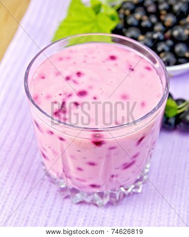 Milkshake with blackcurrants on purple napkin