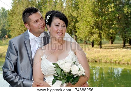 Young bride and groom couple posing outside