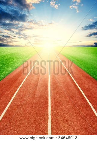 Running track in field with sky and clouds 