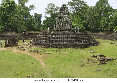 Tourists explore the Neak Pean temple in Angkor, Cambodia.