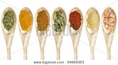 healthy seasoning and spices - a collection of isolated wooded spoons