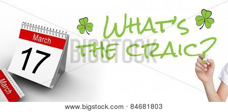 Female hand holding whiteboard marker against shamrock