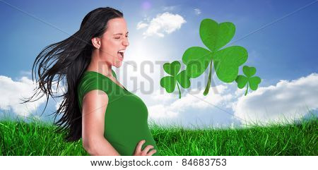 Brunette in green tshirt against cloudy sky with sunshine