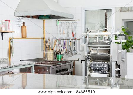 Pasta machine by stove in commercial kitchen