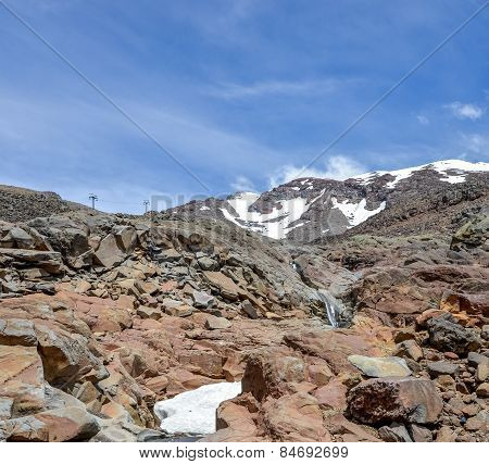 Mount Ruapehu landscape and small watefall flowing under a snow cap in Tongariro National park