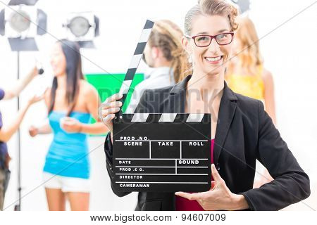 Woman with take clap or board on Film Set of video production for TV, television, news or commercial