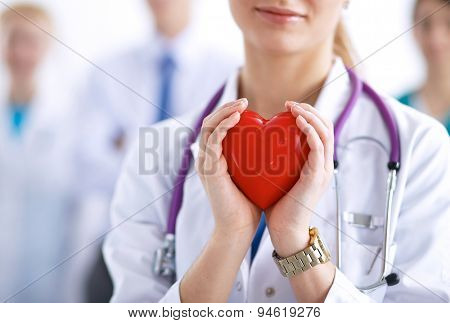 Female doctor with stethoscope holding heart .