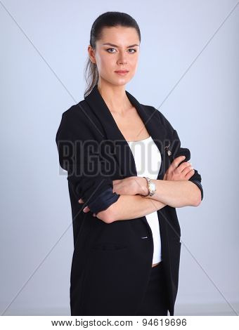 A young woman standing, isolated on graybackground