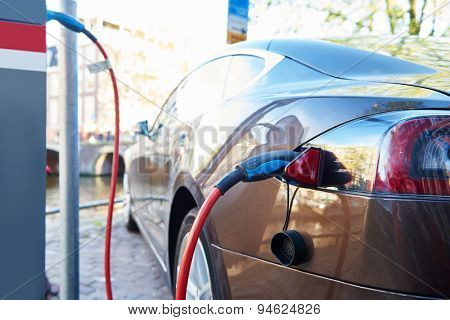Altrernative eco energy fuel. Close up of the power supply plugged into an electric car during charging in Amsterdam