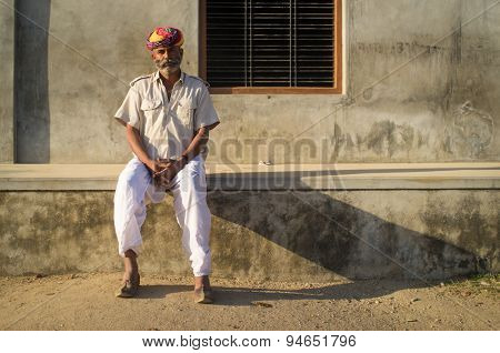 GODWAR REGION, INDIA - 14 FEBRUARY 2015: Adult Indian man with colorful turban and curled mustache sits in street.