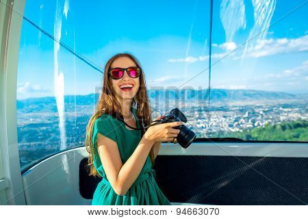 Woman in cable car with cityscape view