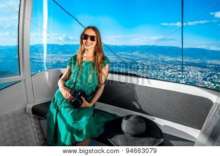 Woman in cable car with cityscape view