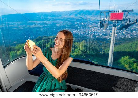 Woman in cable car with cityscape view