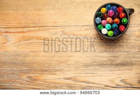 Crayons In A Mug On A Wooden Table