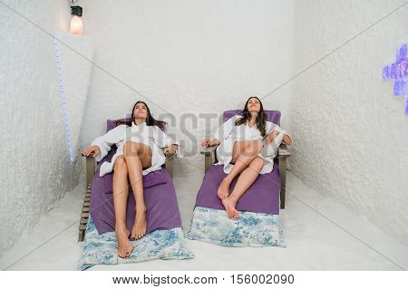Two happy women relaxing in a SPA Salarium salt cave.
