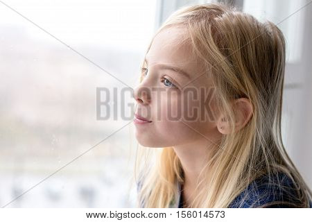 A girl looks out the window and smiling